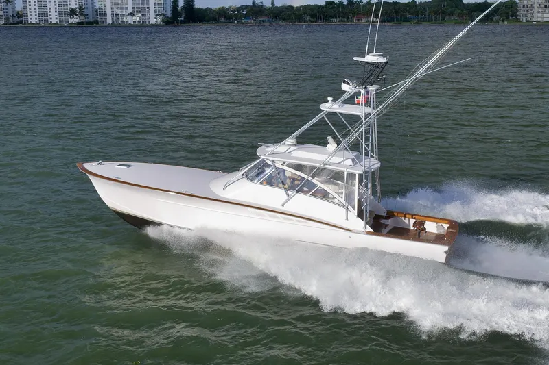Magadi Yacht Photos Pics 2015 Ritchie Howell Express boat cruising on water near city skyline.