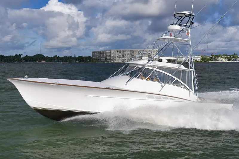 Magadi Yacht Photos Pics 2015 Ritchie Howell Express boat cruising on water under cloudy sky.
