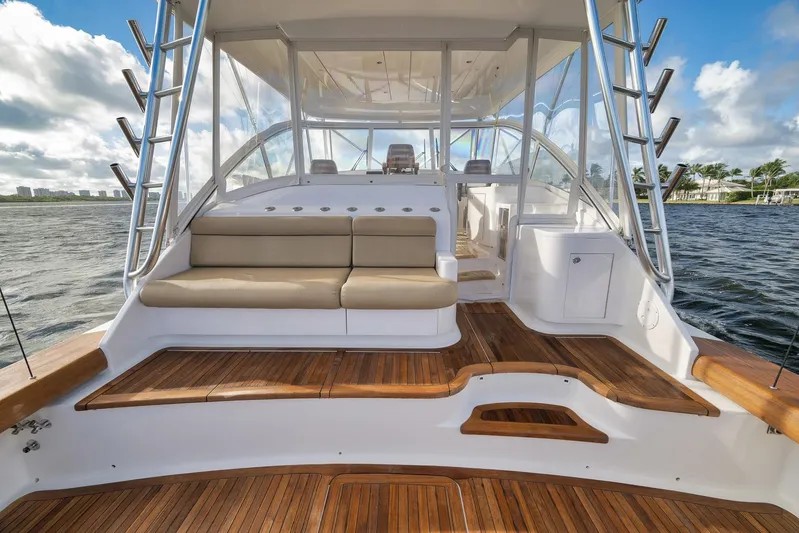 Magadi Yacht Photos Pics 2015 Ritchie Howell Express yacht with teak deck and cushioned seating, docked by the water.