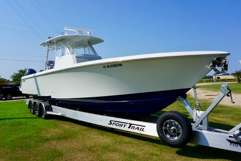  Yacht Photos Pics 2022 Contender 39 Fisharound boat on trailer, parked on grass under clear blue sky.