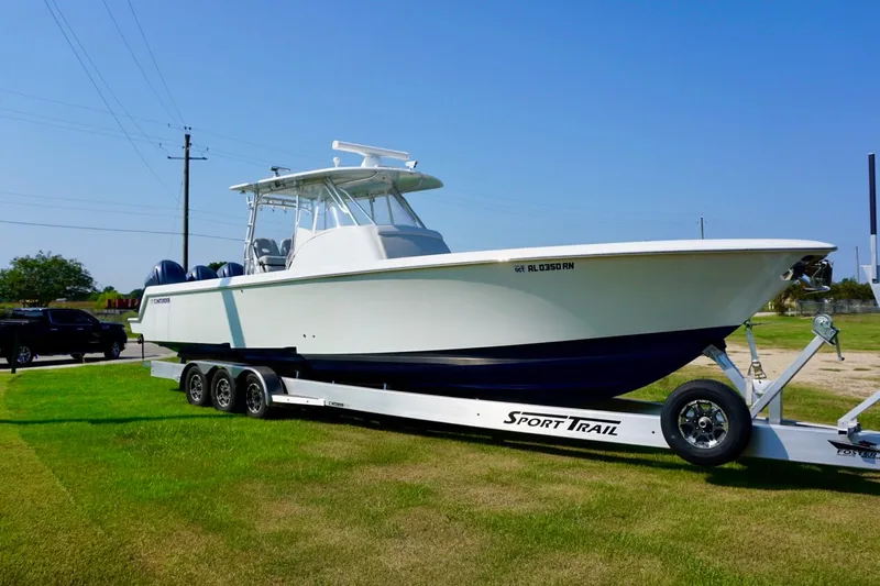  Yacht Photos Pics 2022 Contender 39 Fisharound boat on Sport Trail trailer, parked on grass.
