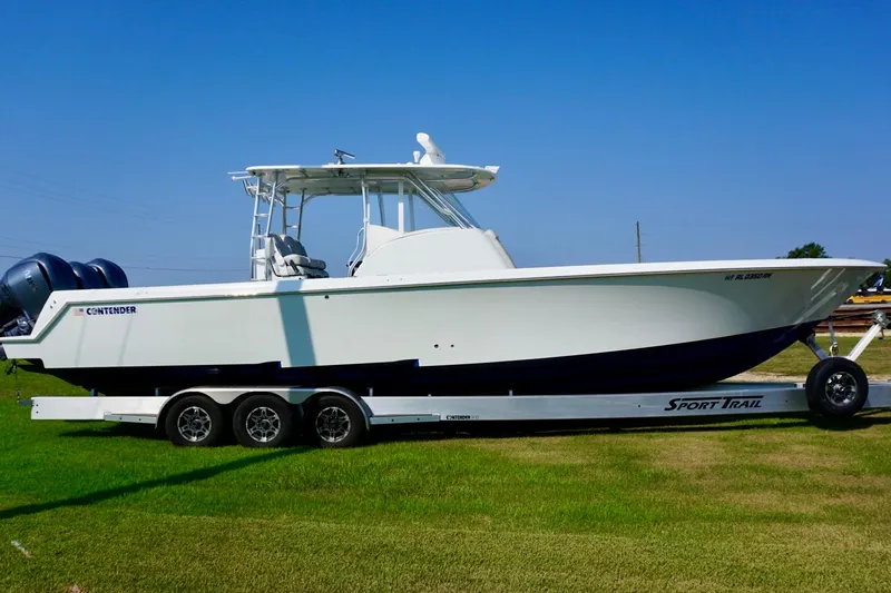  Yacht Photos Pics 2022 Contender 39 Fisharound boat on trailer, parked on grass under clear blue sky.