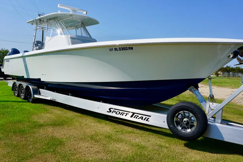  Yacht Photos Pics 2022 Contender 39 Fisharound boat on trailer, parked on grass under clear sky.