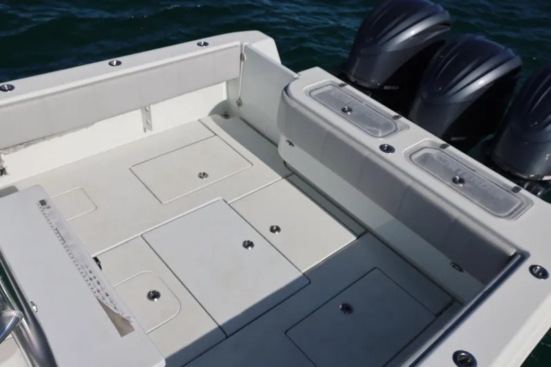  Yacht Photos Pics 2022 Contender 39 Fisharound boat deck with storage compartments and triple outboard engines.