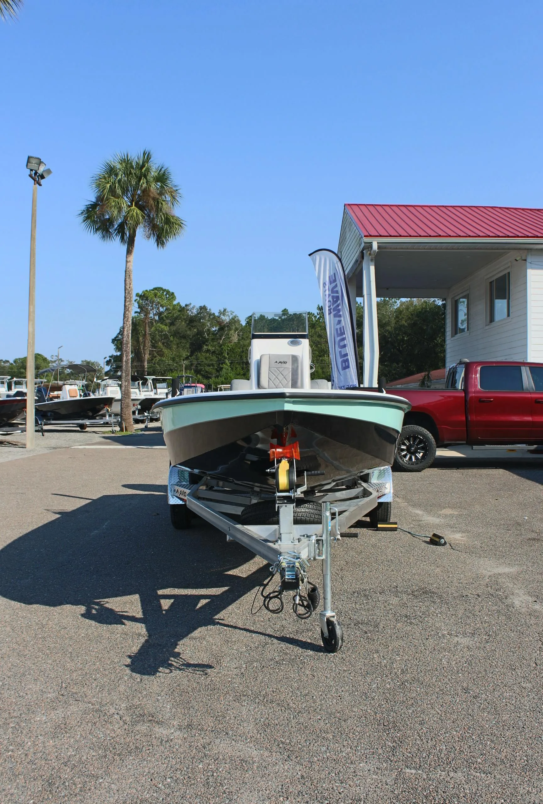 2025 Avid 23 FSX boat on trailer in sunny outdoor setting.