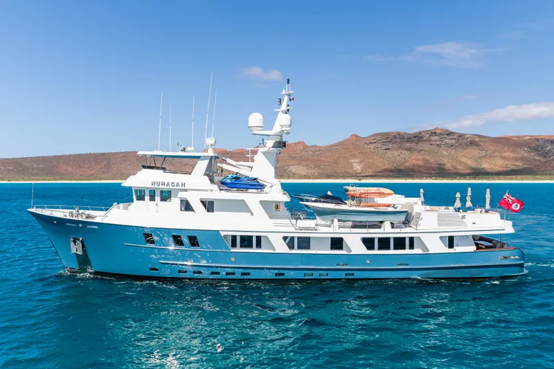 Huracan Yacht Photos Pics Delta Marine Expedition yacht, 1991 model, cruising in clear blue waters with scenic background.