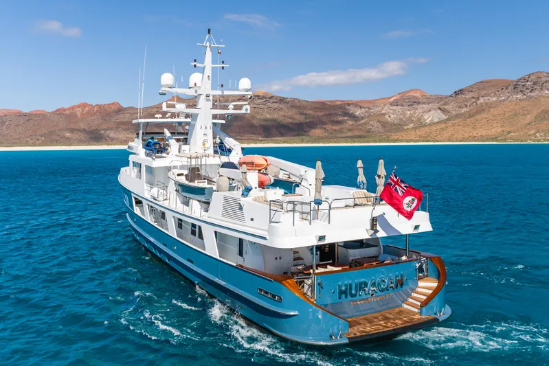 Huracan Yacht Photos Pics Luxurious 1991 Delta Marine Expedition yacht cruising in clear blue waters near scenic coastline.