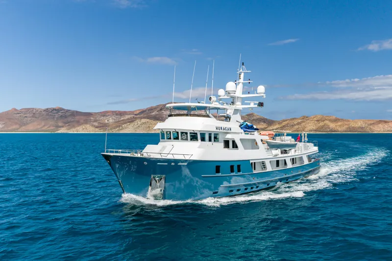 Huracan Yacht Photos Pics Luxury Delta Marine Expedition yacht cruising in clear blue waters, 1991 model.