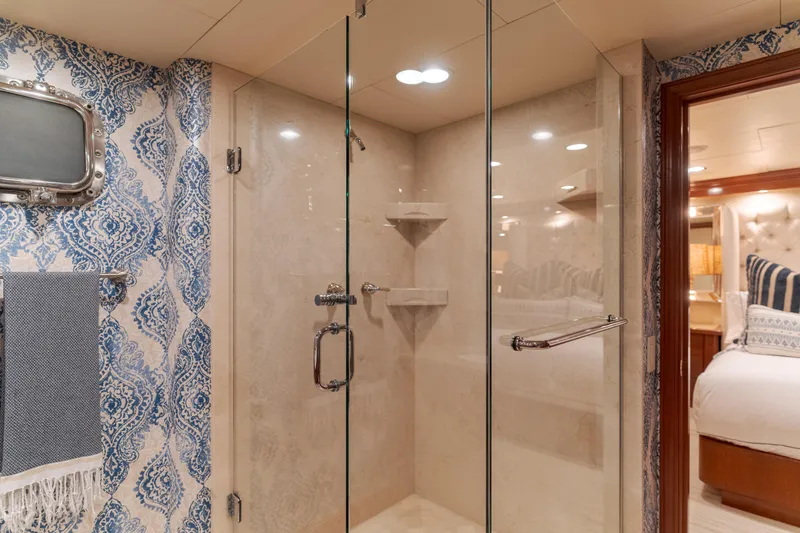 Huracan Yacht Photos Pics Luxurious yacht bathroom with glass shower, elegant wallpaper, and cozy bedroom view. Delta Marine Expedition 1991.