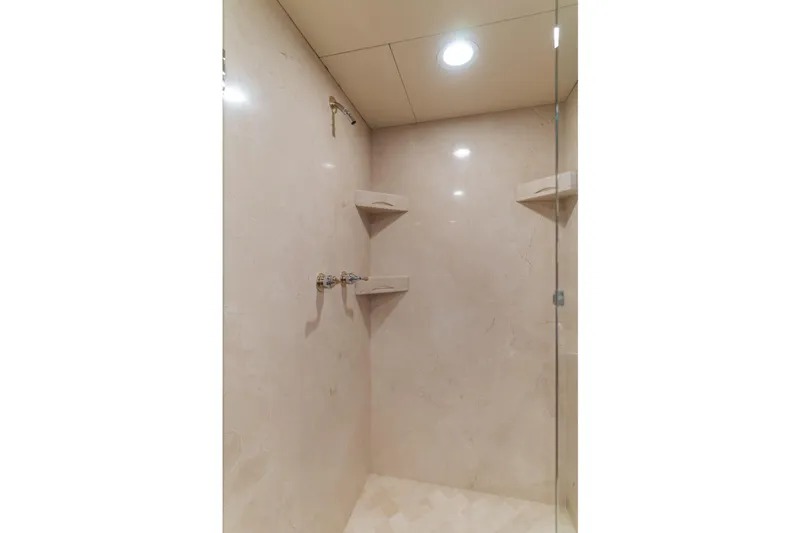 Huracan Yacht Photos Pics Luxurious shower interior on 1991 Delta Marine Expedition yacht, featuring elegant marble walls and shelving.