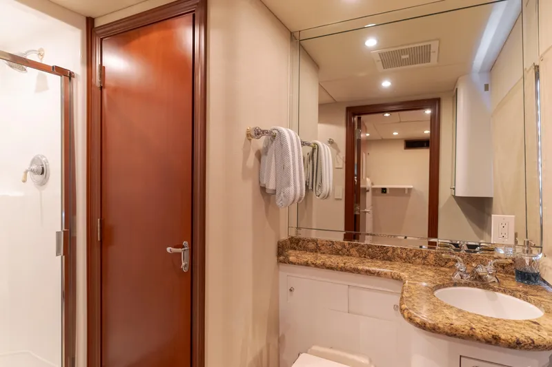 Huracan Yacht Photos Pics Luxurious bathroom on 1991 Delta Marine Expedition yacht with granite countertop and wooden door.