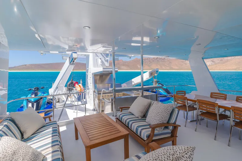 Huracan Yacht Photos Pics Luxurious 1991 Delta Marine Expedition yacht deck with seating, dining area, and ocean view.