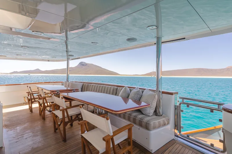 Huracan Yacht Photos Pics Luxurious Delta Marine Expedition yacht deck with seating, overlooking serene blue waters and distant hills.