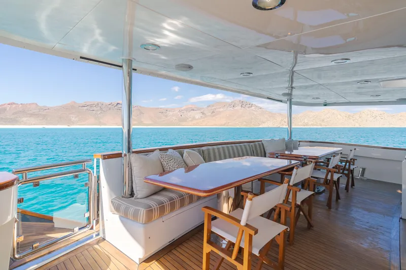 Huracan Yacht Photos Pics Luxurious Delta Marine Expedition yacht deck with seating, overlooking serene blue waters and distant mountains.