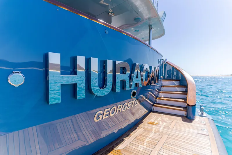 Huracan Yacht Photos Pics Blue Delta Marine Expedition yacht, 1991, with "HURACAN" lettering, docked in clear waters.