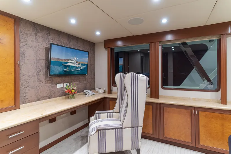 Huracan Yacht Photos Pics Luxurious interior of 1991 Delta Marine Expedition yacht with elegant desk and striped chair.