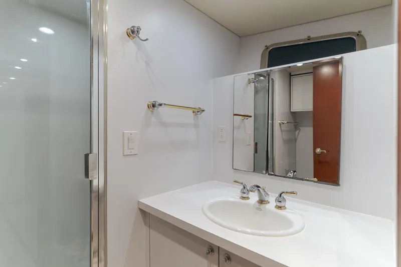Huracan Yacht Photos Pics Bathroom interior of 1991 Delta Marine Expedition yacht with sink, mirror, and shower.