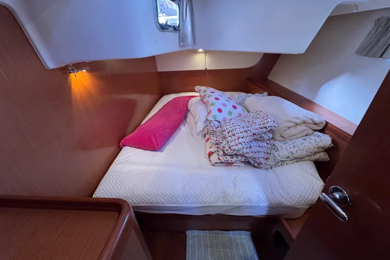 Wakadui Yacht Photos Pics Cozy cabin interior of 2009 Benetea 49 yacht with bed and colorful pillows.