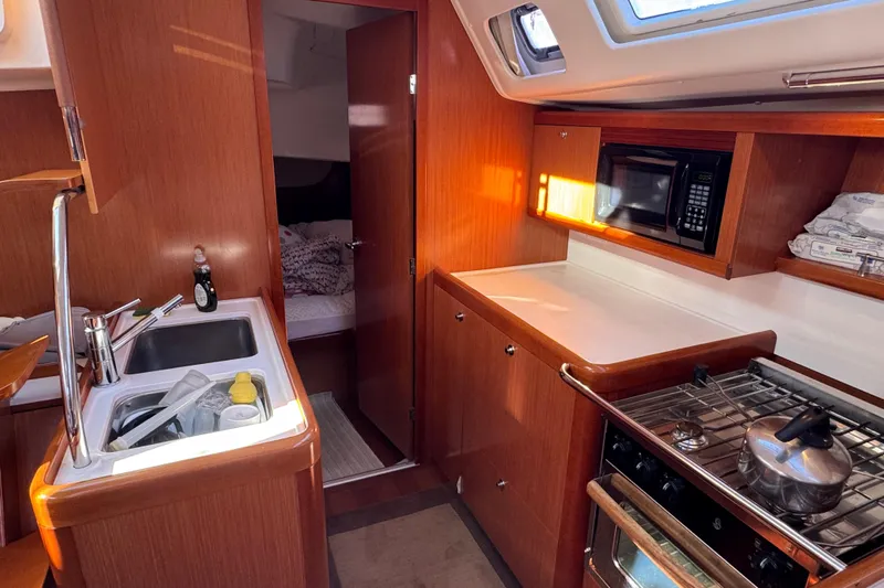 Wakadui Yacht Photos Pics Interior of a 2009 Benetea 49 yacht kitchen with wooden cabinetry and modern appliances.