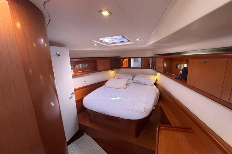 Wakadui Yacht Photos Pics Luxurious cabin interior of a 2009 Benetea 49 yacht with cozy bed and wooden finish.
