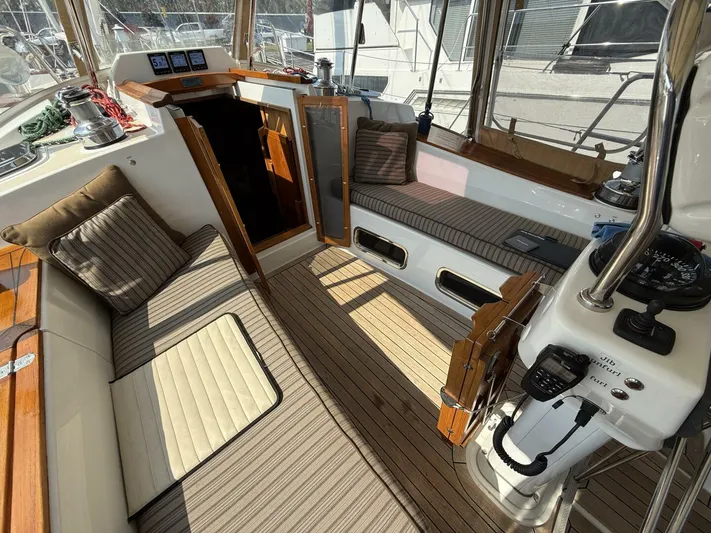  Yacht Photos Pics Cozy interior of 2011 Tartan 4300 sailboat with striped cushions and navigation equipment.
