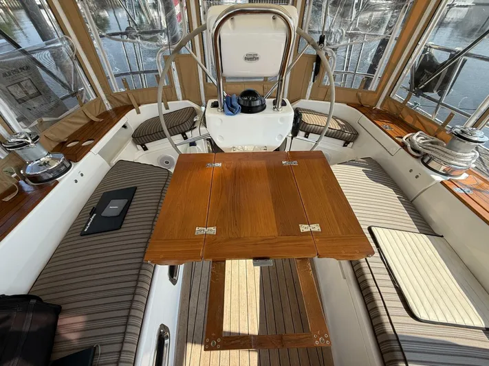  Yacht Photos Pics Interior of 2011 Tartan 4300 sailboat with wooden table and striped seating.