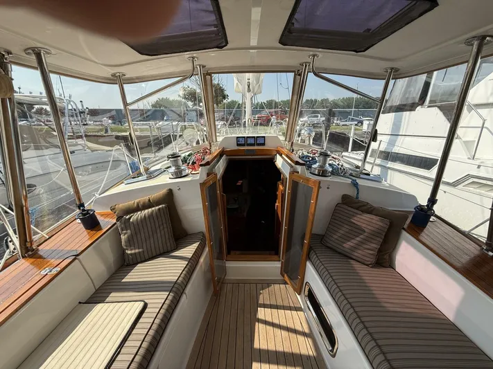  Yacht Photos Pics Interior view of 2011 Tartan 4300 sailboat with cushioned seating and wooden accents.