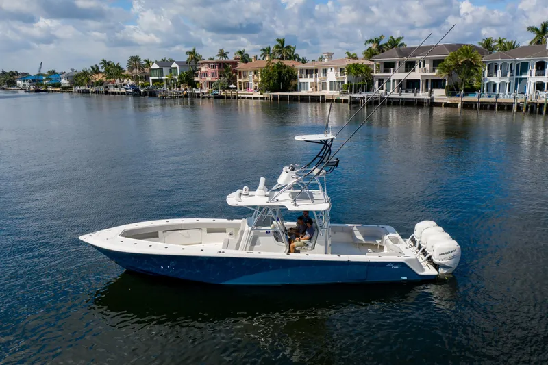 Yacht Photos Pics 2021 SeaVee 390Z boat on calm water, with luxury waterfront homes in the background.