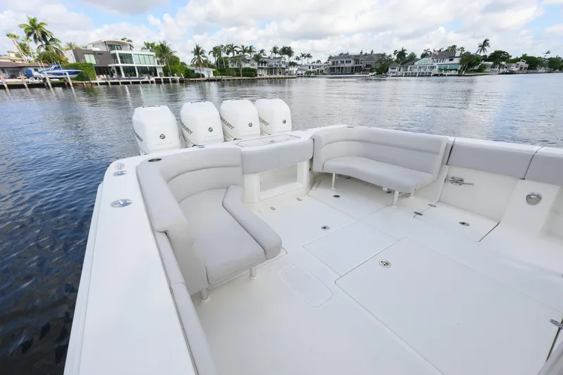  Yacht Photos Pics 2021 SeaVee 390Z boat with spacious seating and multiple outboard engines on a calm waterfront.