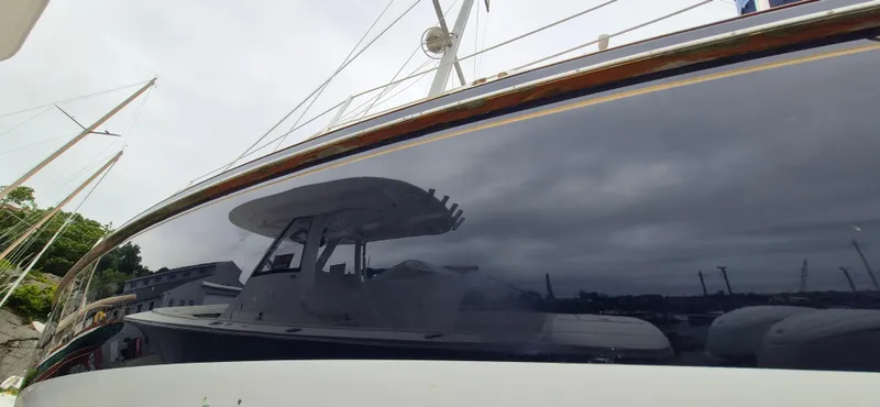 Blue Skies Yacht Photos Pics Sleek 1990 Able Chuck Paine Sloop with reflective hull in a marina setting.