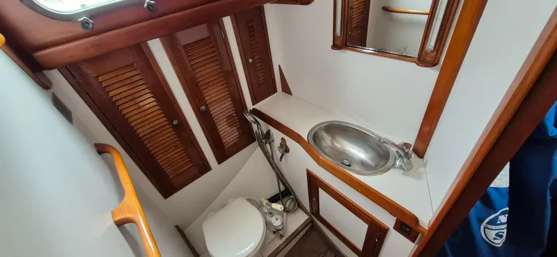 Blue Skies Yacht Photos Pics 1990 Able Chuck Paine Sloop bathroom with wooden accents and stainless steel sink.