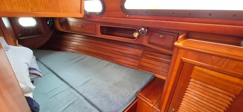 Blue Skies Yacht Photos Pics Cozy cabin interior of 1990 Able Chuck Paine Sloop with wooden finish and bedding.