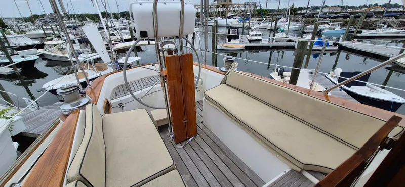 Blue Skies Yacht Photos Pics 1990 Able Chuck Paine Sloop cockpit with cushioned seating, docked in a marina.