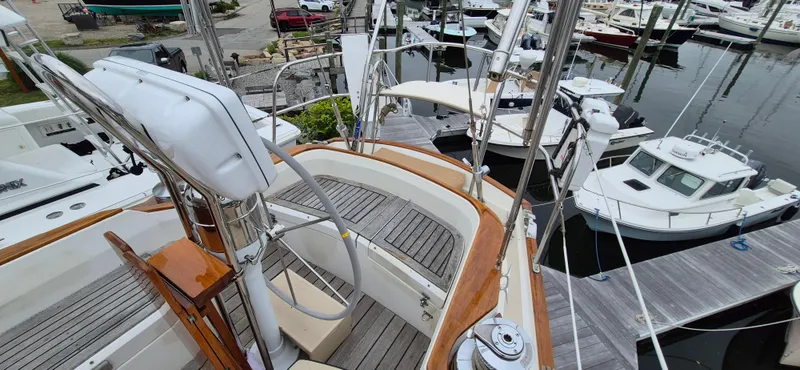Blue Skies Yacht Photos Pics 1990 Able Chuck Paine Sloop with wooden deck, docked among other boats at a marina.