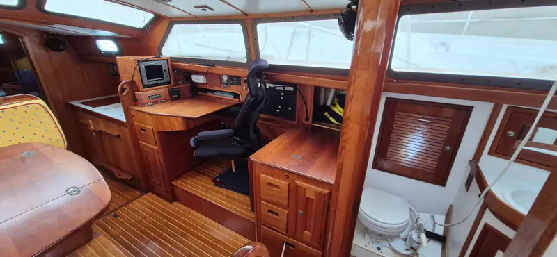 Blue Skies Yacht Photos Pics Interior of 1990 Able Chuck Paine Sloop, featuring navigation station and wooden cabinetry.
