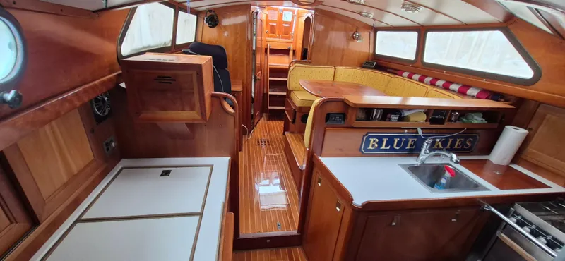 Blue Skies Yacht Photos Pics Interior of 1990 Able Chuck Paine Sloop with wood finish and cozy seating area.