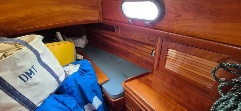 Blue Skies Yacht Photos Pics Cozy cabin interior of 1990 Able Chuck Paine Sloop with wooden finish and storage.
