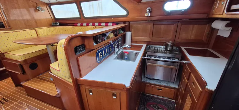 Blue Skies Yacht Photos Pics Cozy 1990 Able Chuck Paine Sloop interior with kitchen and dining area.