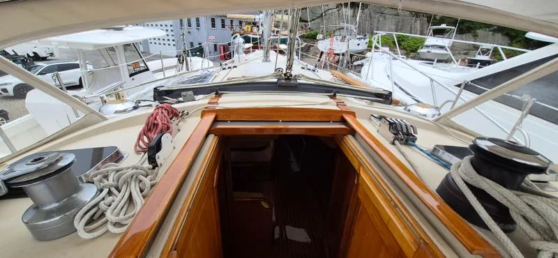 Blue Skies Yacht Photos Pics Able Chuck Paine Sloop 1990 sailboat deck with ropes and winches in a marina.