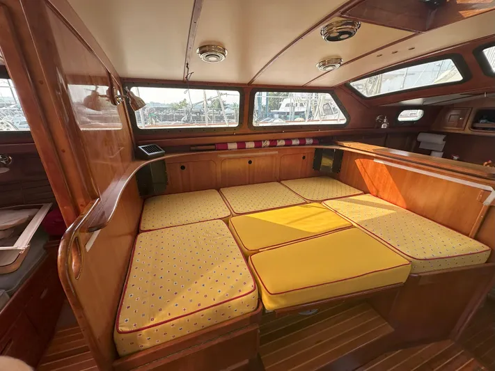 Blue Skies Yacht Photos Pics Cozy interior of 1990 Able Chuck Paine Sloop with yellow cushioned seating.