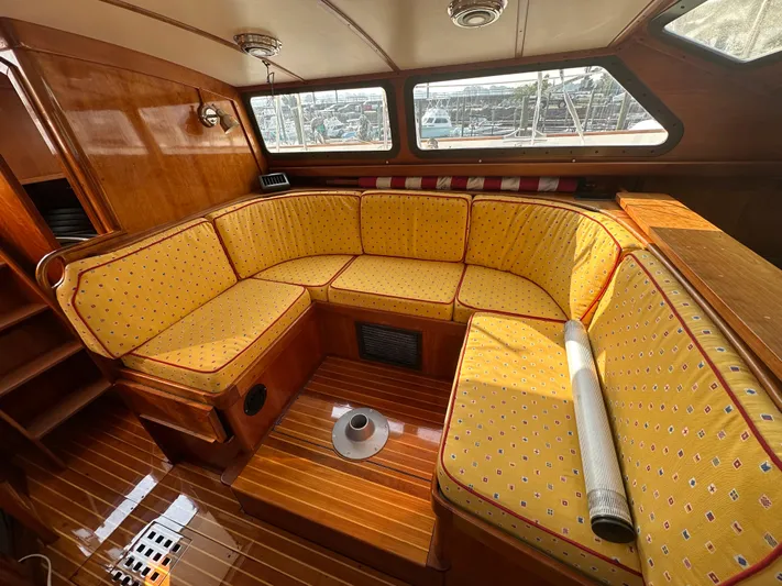 Blue Skies Yacht Photos Pics Cozy interior of 1990 Able Chuck Paine Sloop with yellow cushioned seating.