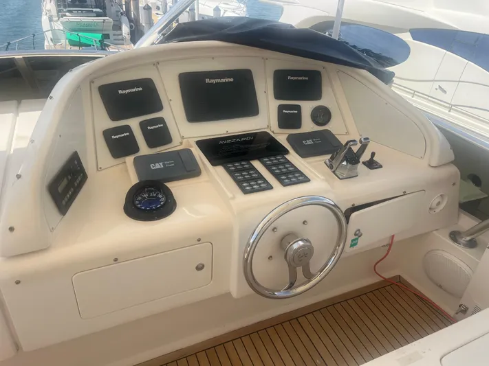 Yacht Photos Pics Control panel of a 2000 Rizzardi 75 yacht with navigation instruments and steering wheel.