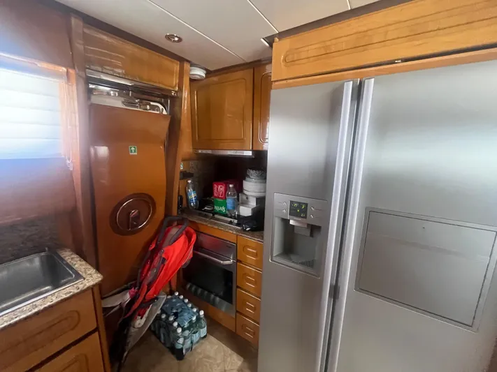  Yacht Photos Pics Kitchen interior of 2000 Rizzardi 75 yacht with wooden cabinets and stainless steel appliances.