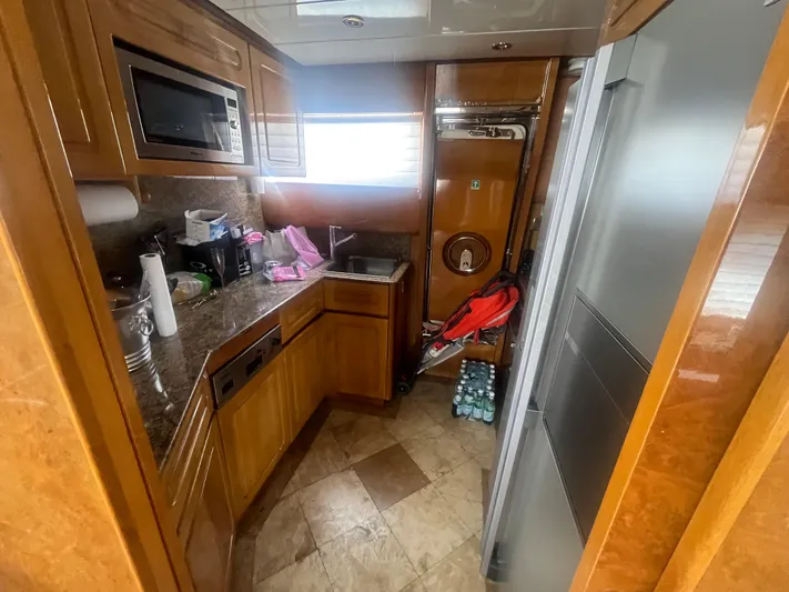  Yacht Photos Pics Kitchen area in a 2000 Rizzardi 75 yacht with wooden cabinetry and modern appliances.