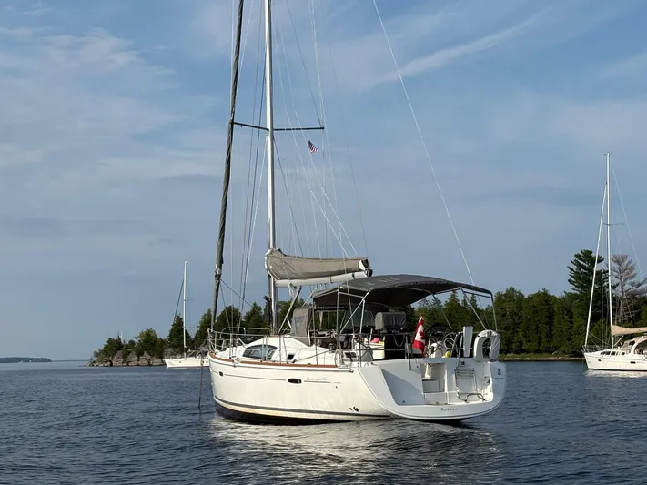 Farenheight Yacht Photos Pics 2008 Beneteau Oceanis 40 sailboat anchored on calm water, surrounded by trees and other boats.