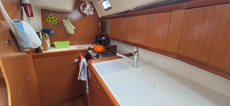 Farenheight Yacht Photos Pics Galley kitchen in 2008 Beneteau Oceanis 40 sailboat with wooden cabinets and modern amenities.