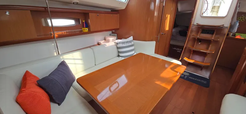 Farenheight Yacht Photos Pics Interior of 2008 Beneteau Oceanis 40 yacht with cozy seating and wooden table.