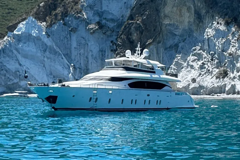  Yacht Photos Pics Luxurious 2010 Maiora 27 yacht cruising near rocky cliffs in clear blue waters.