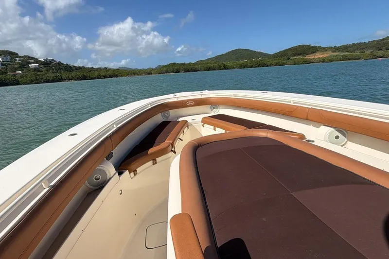  Yacht Photos Pics 2015 Scout 350 LXF boat interior with brown seating, on calm water, under blue sky.