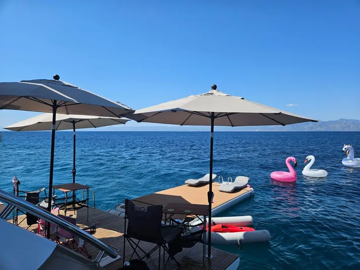 Murano Yacht Photos Pics Luxury yacht deck with umbrellas and inflatables on the water, Azimut 72 FLY 2018.